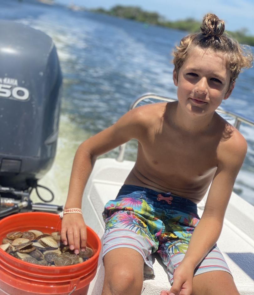 Fresh catch of scallops displayed in orange bucket on boat deck