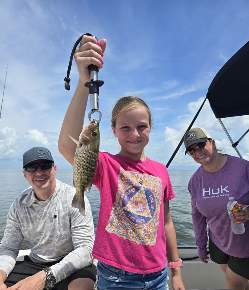 Grey snapper caught on fishing trip held up on boat