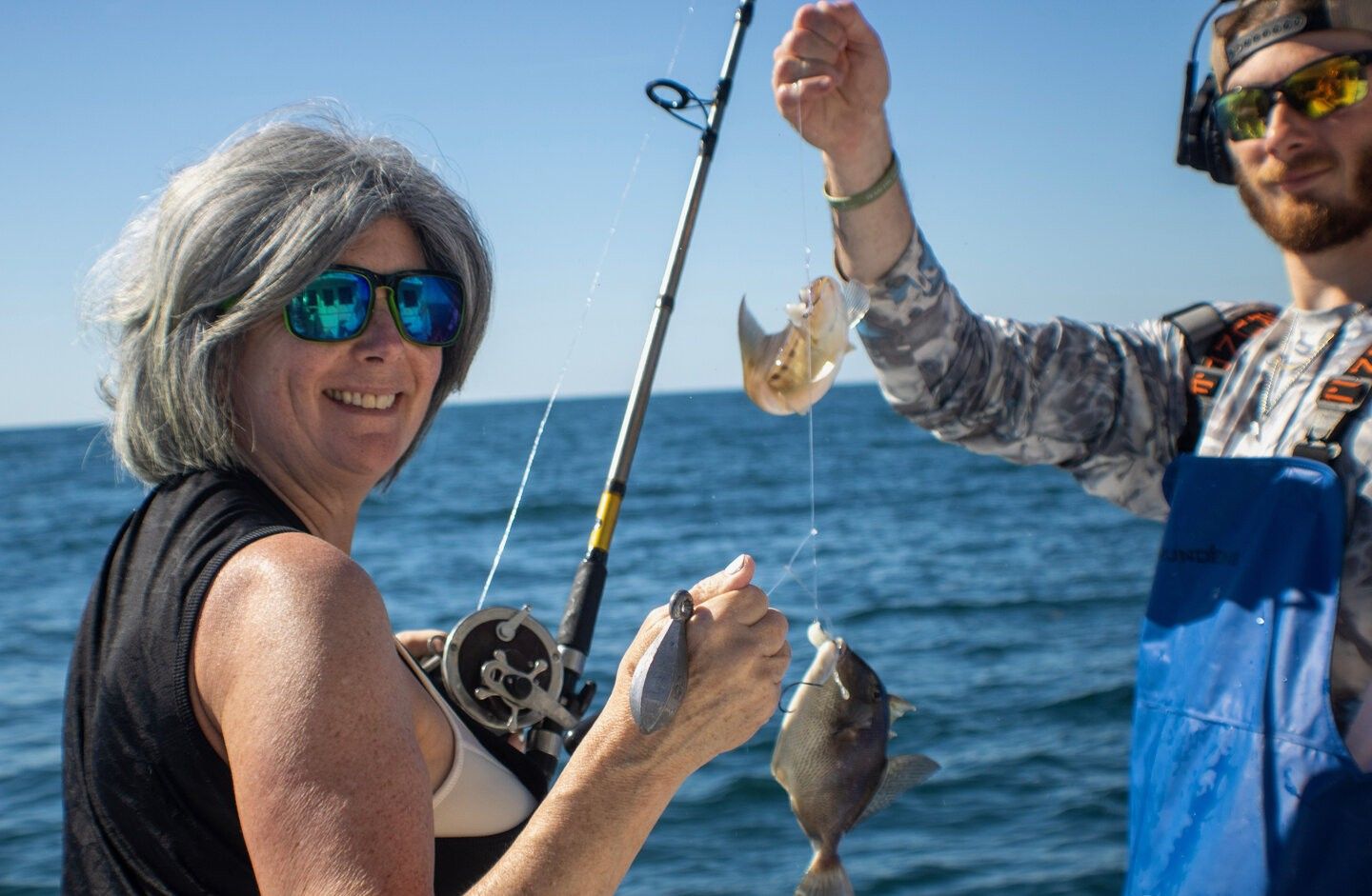 Fishing catch showing Grey Triggerfish being held up on boat with ocean in background