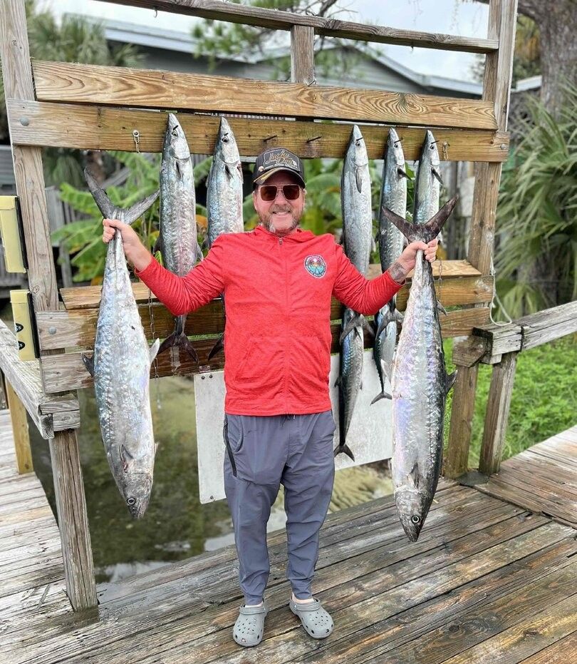 Fresh caught king mackerel displayed on wooden fish cleaning station after successful fishing trip