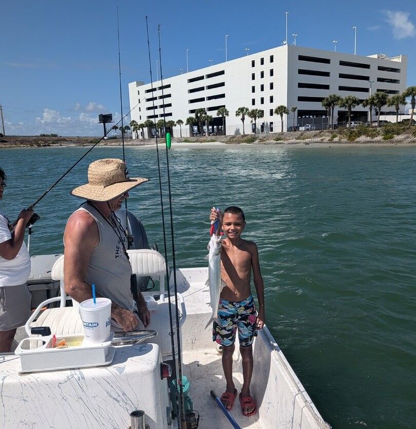 Ladyfish caught during fishing trip on boat near waterfront building