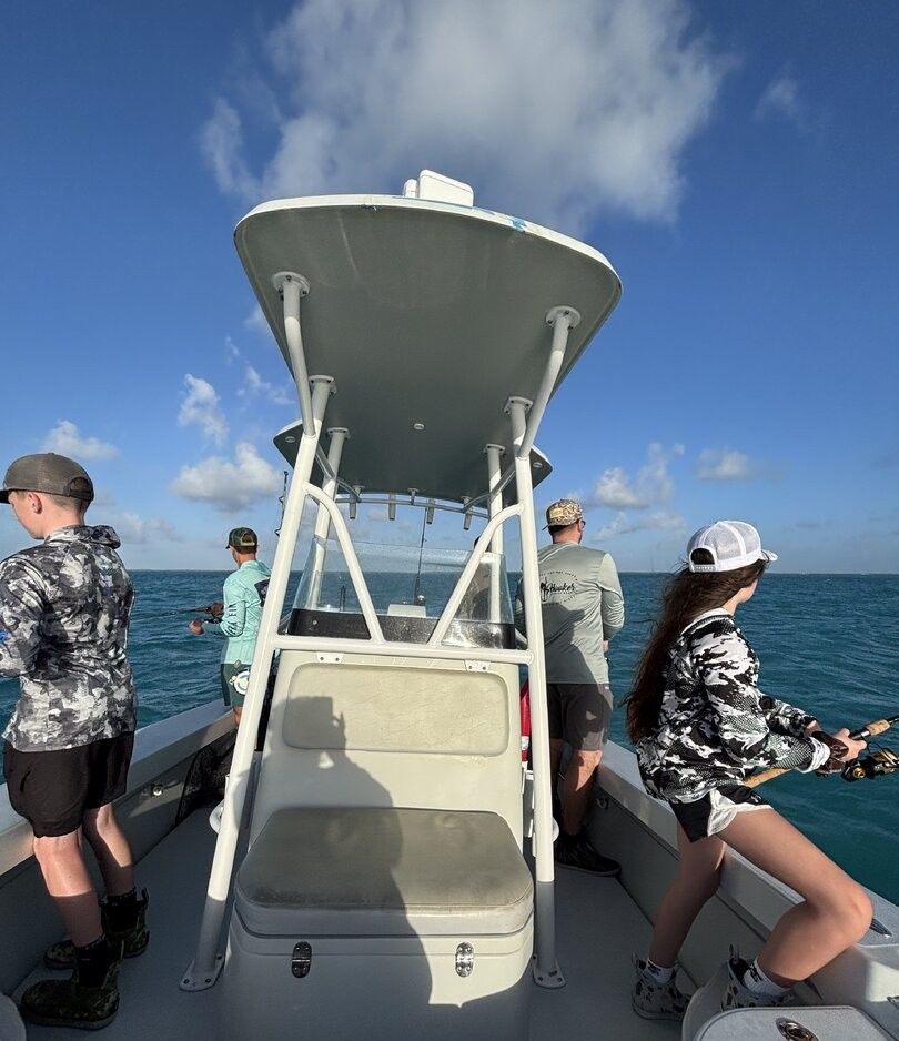 Fishing boat on ocean water with T-top shade structure and center console design