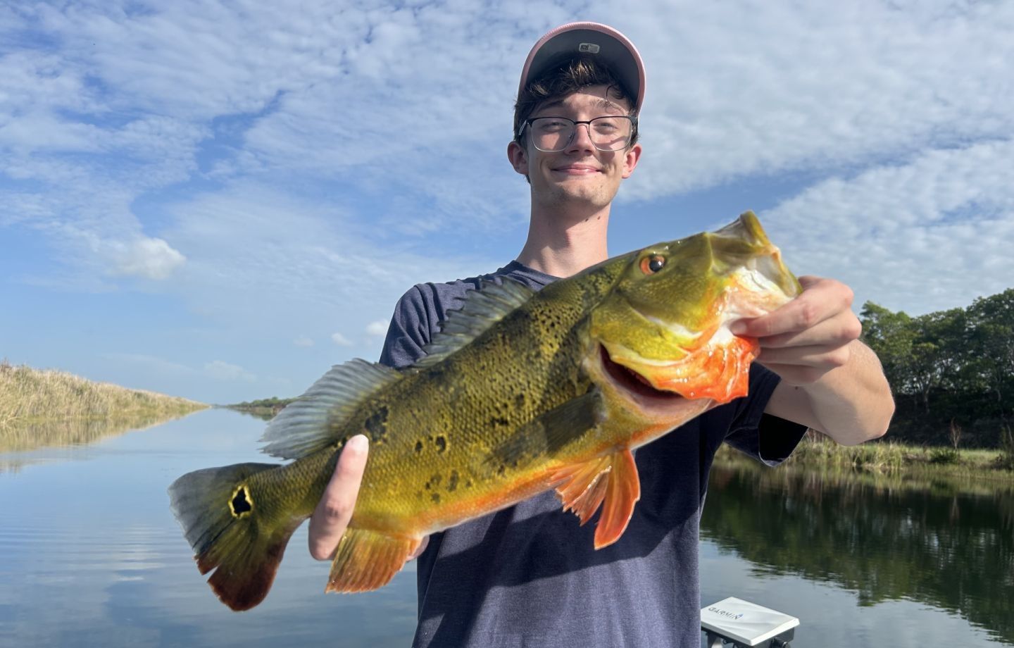 Peacock bass catch displayed outdoors by water