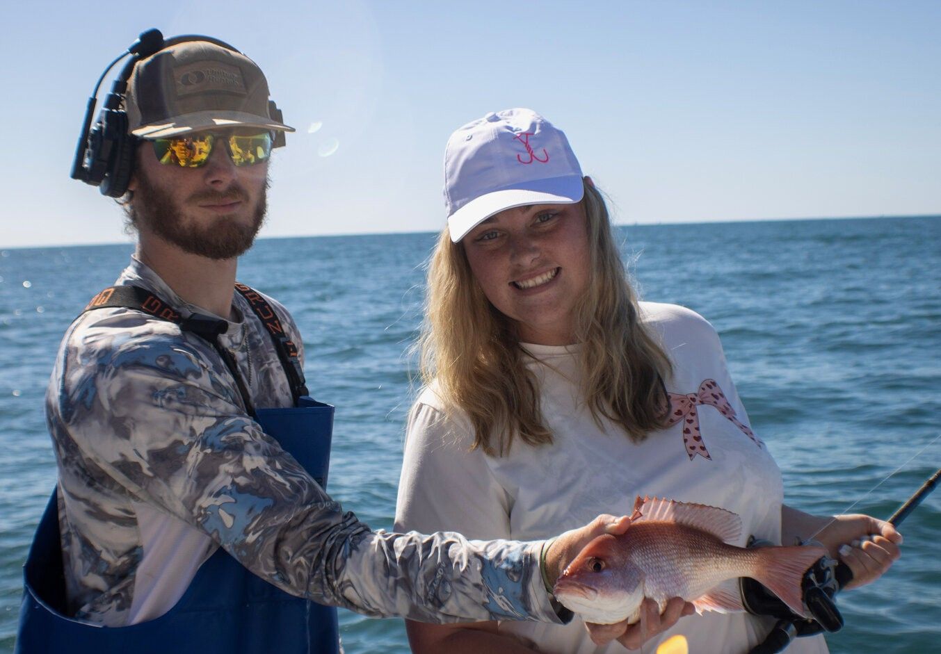 Red snapper catch displayed on fishing boat over blue ocean water