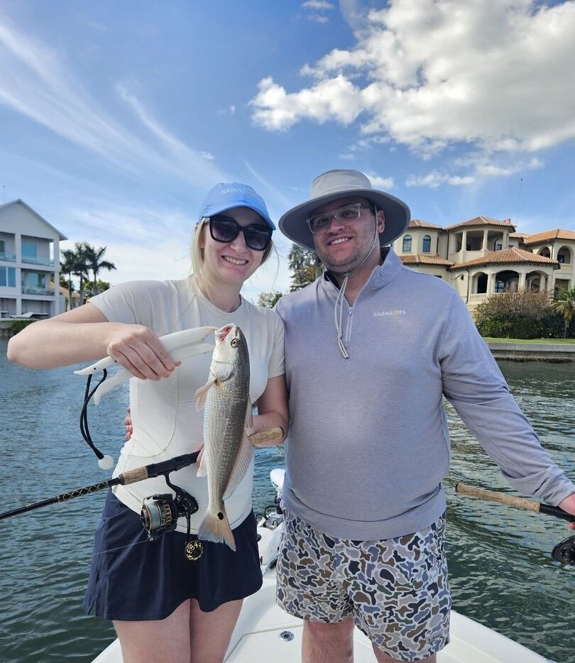 Freshly caught redfish displayed on fishing boat with rod and reel
