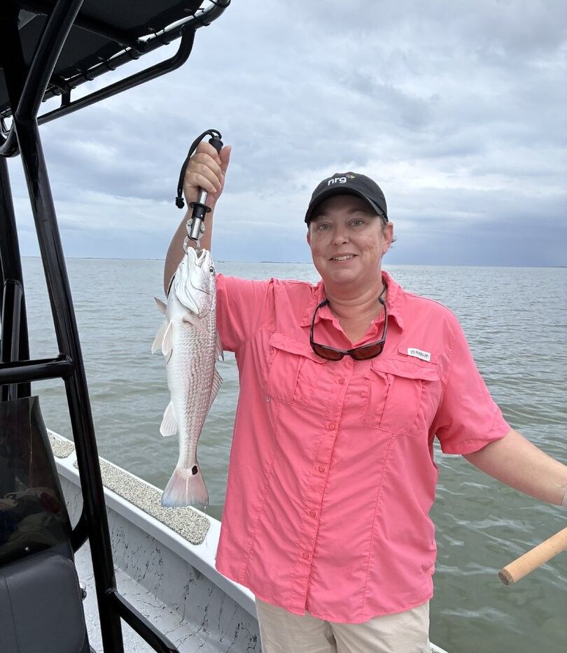 Angler holding freshly caught redfish on fishing boat