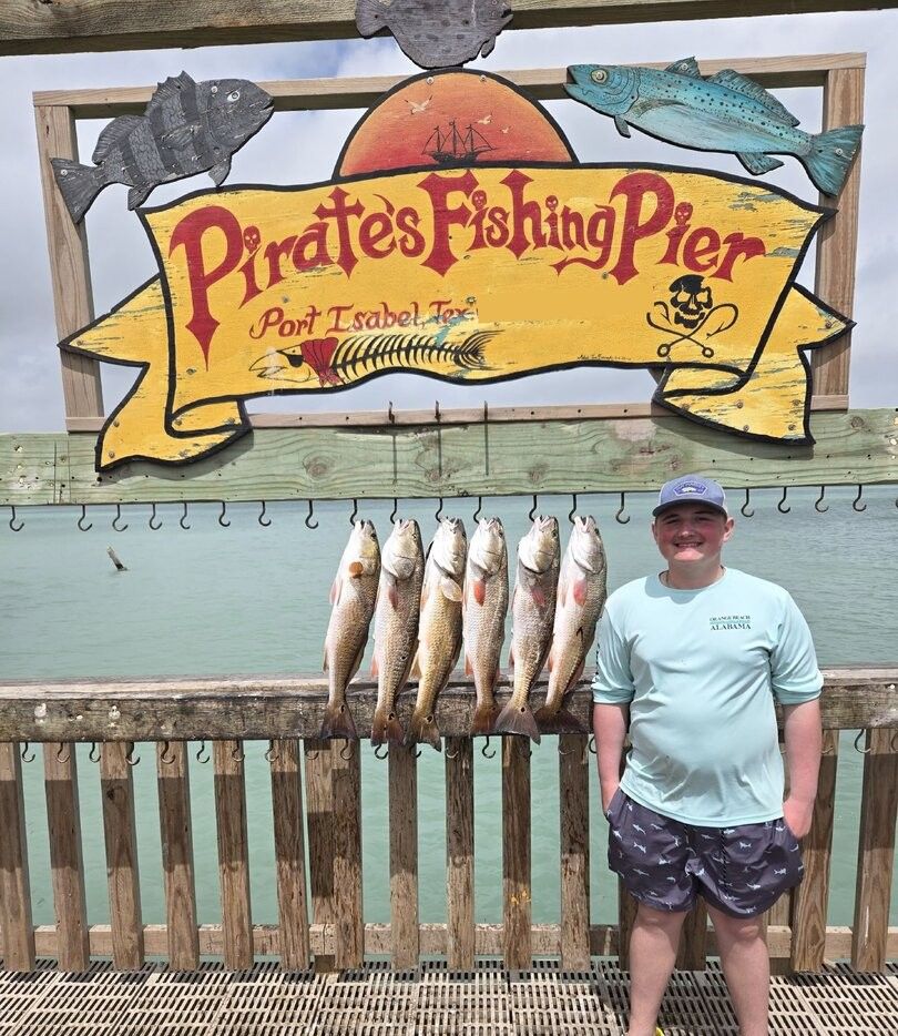 Six redfish hanging on display hooks at Pirates Fishing Pier