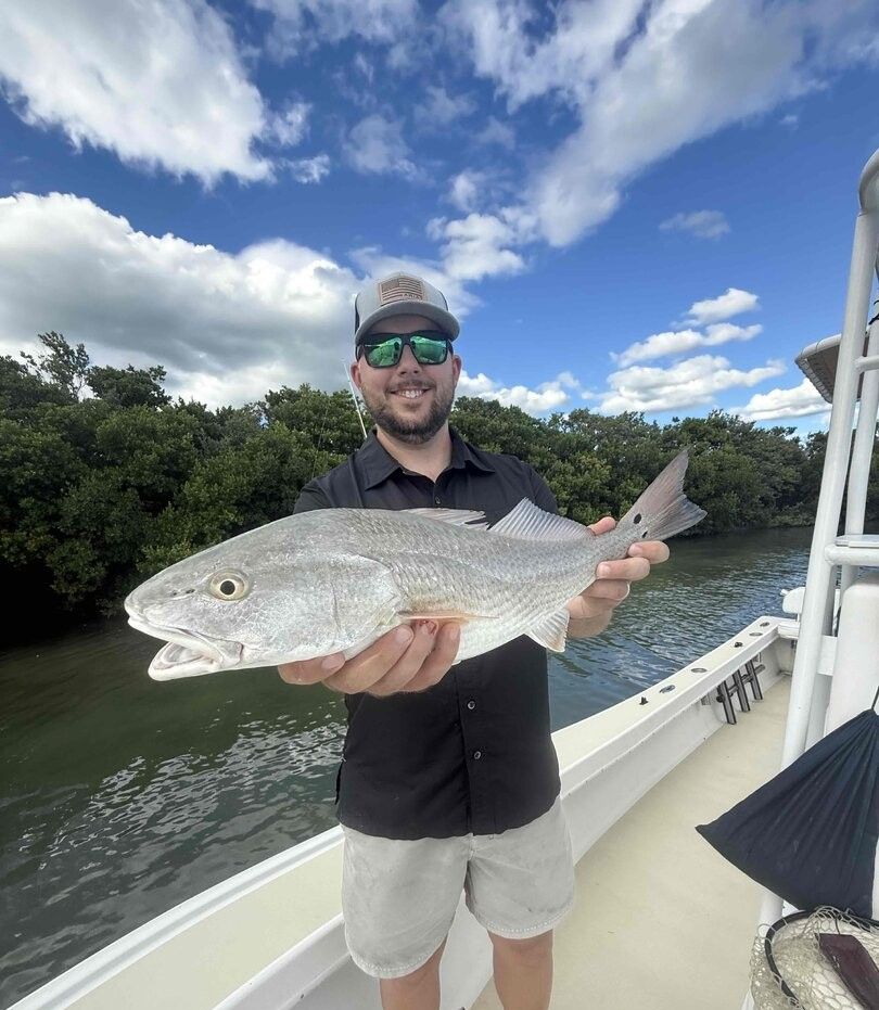 Angler holding freshly caught redfish on fishing boat