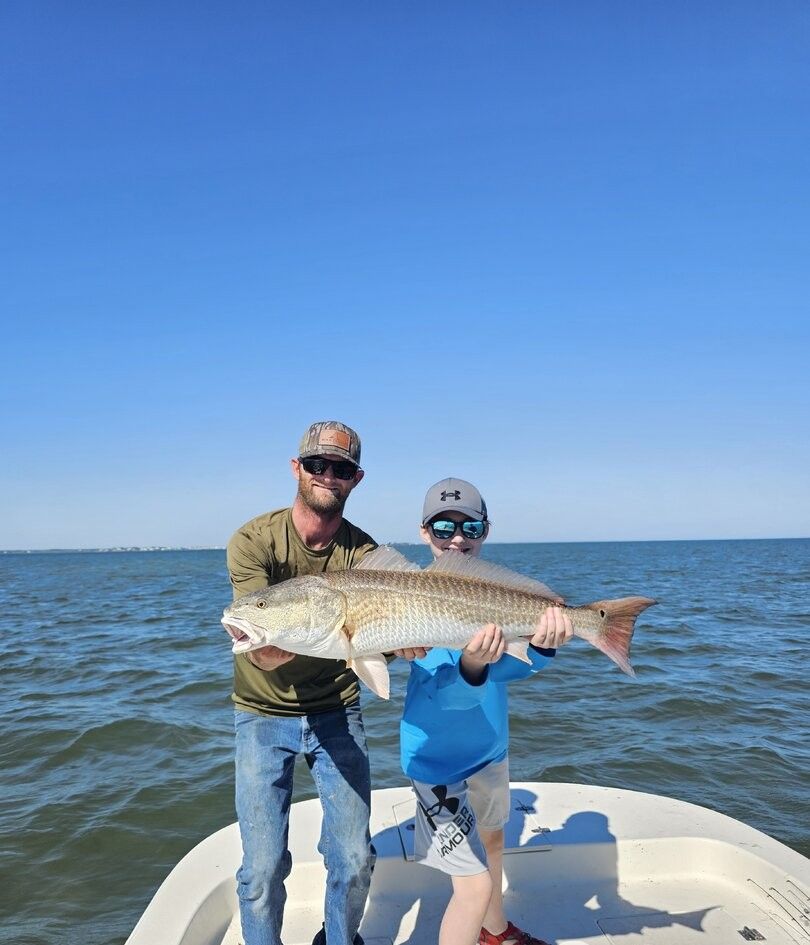 Fishing charter displaying caught redfish on boat deck over open water