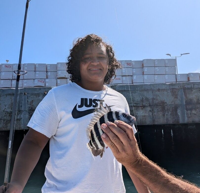 Freshly caught sheepshead fish being held up outdoors
