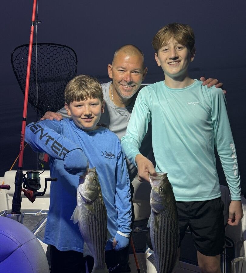 Successful striped bass fishing trip with two caught fish on boat