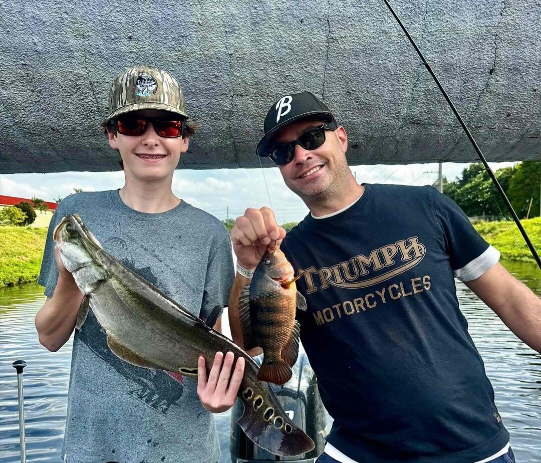 Two blue tilapia fish being caught while fishing