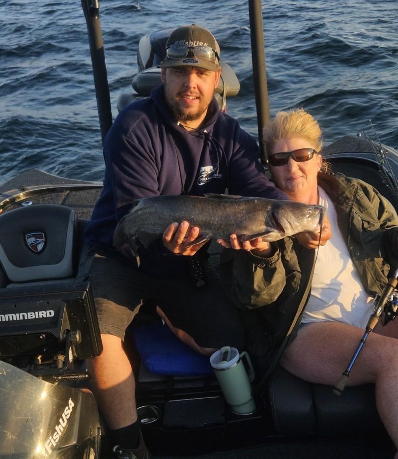Fresh caught fish displayed on fishing boat with fishing rods and equipment visible on open water