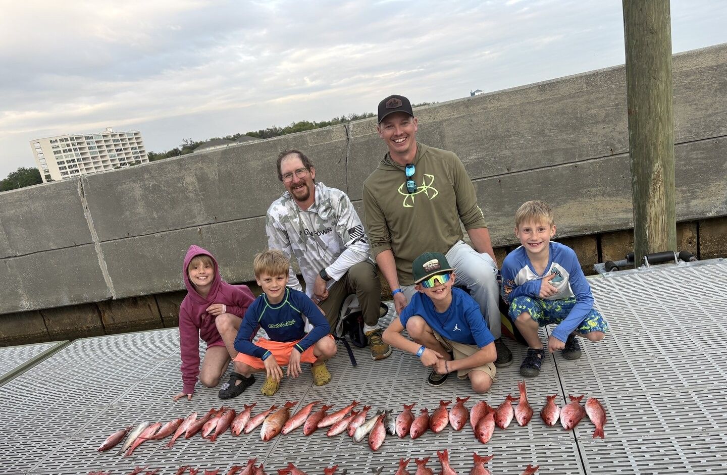 Successful fishing trip showing multiple red snapper fish laid out on dock