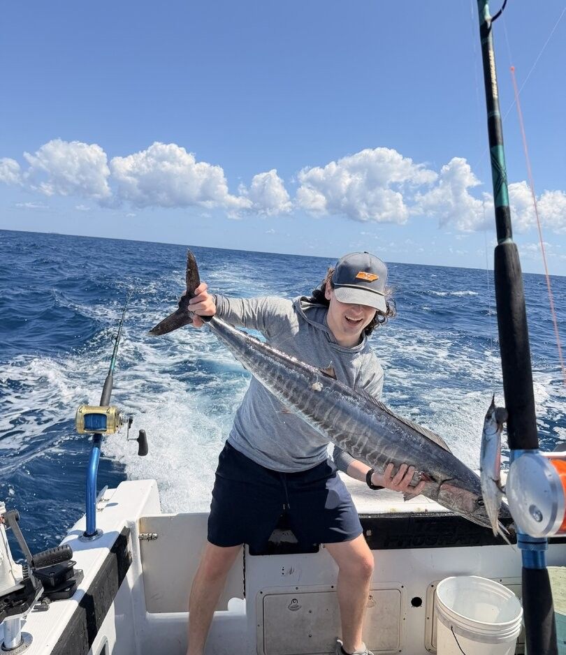 Wahoo fish catch displayed on fishing boat deck with ocean in background