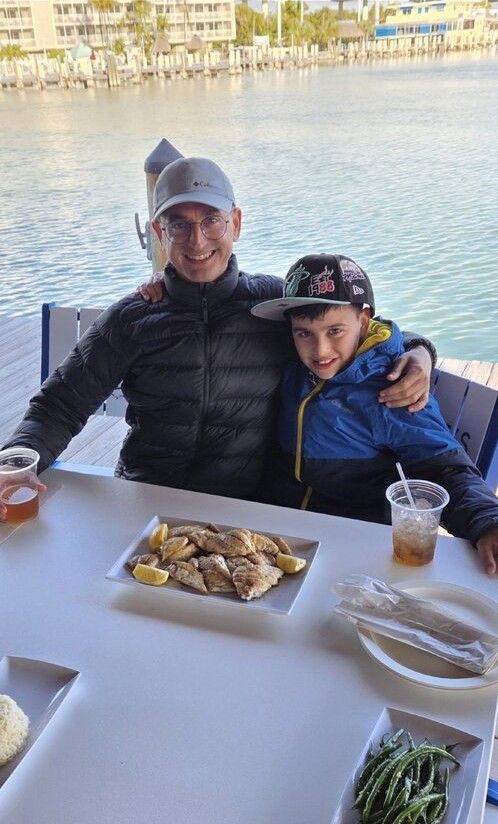 Fresh fish served on outdoor waterside dining table with marina in background