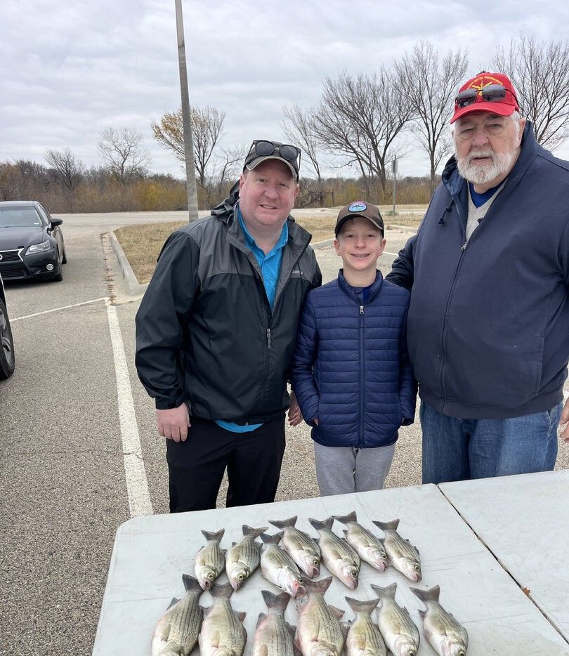 Fishing trip results showing fresh caught white bass displayed on table in outdoor parking area