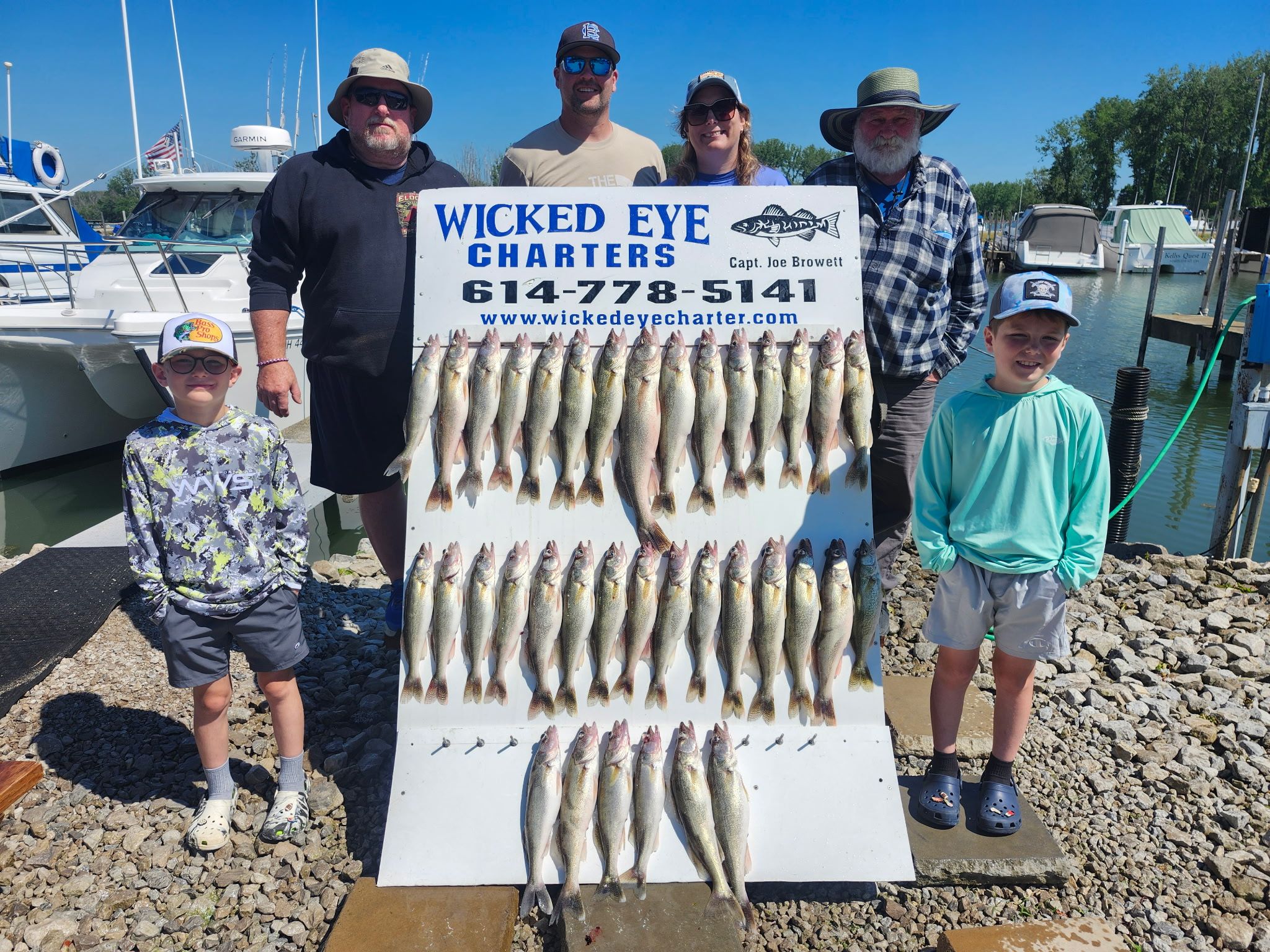 Large catch of walleye fish displayed on white board at marina dock