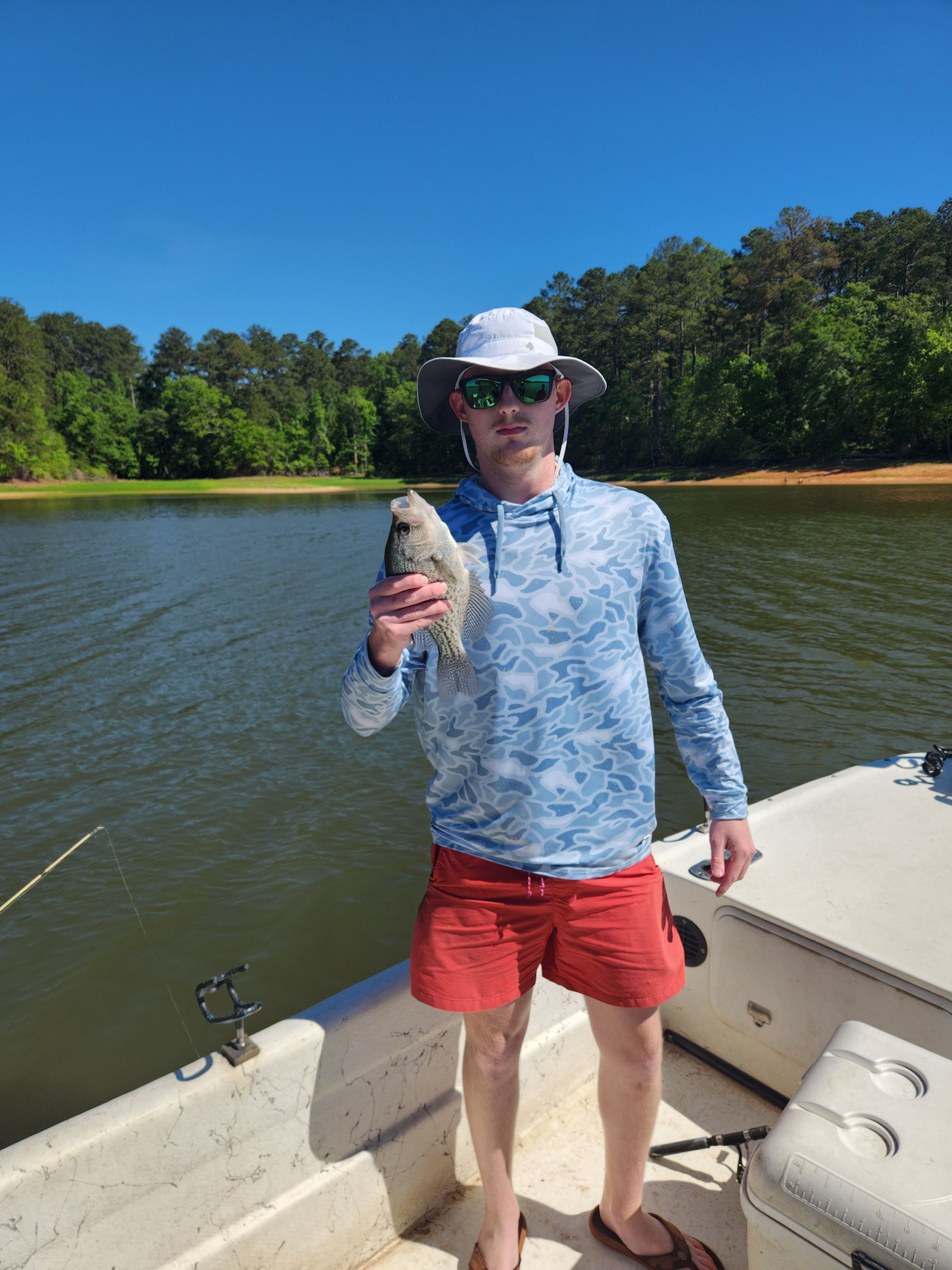 Angler holding freshly caught crappie on fishing boat