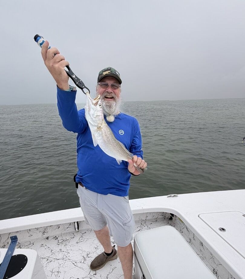 Angler holding caught fish on fishing boat