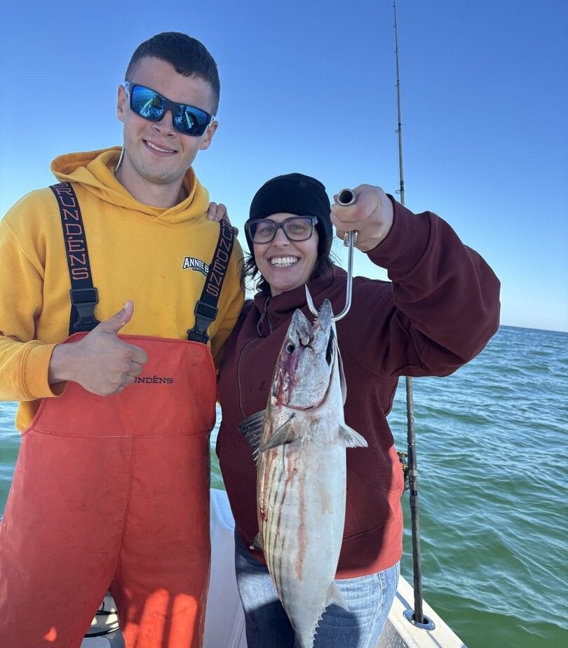 Fresh Atlantic bonito catch displayed on fishing boat with ocean and fishing rod in background