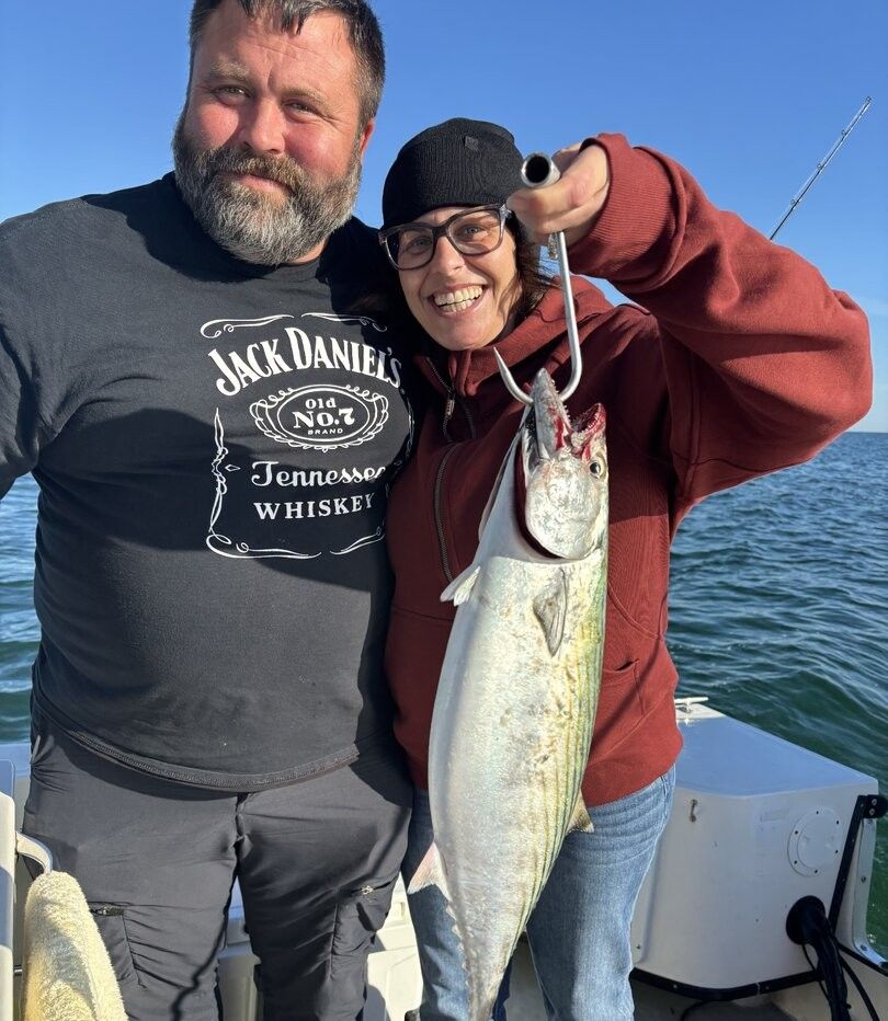 Fishing catch showing Atlantic bonito held on boat deck over ocean water