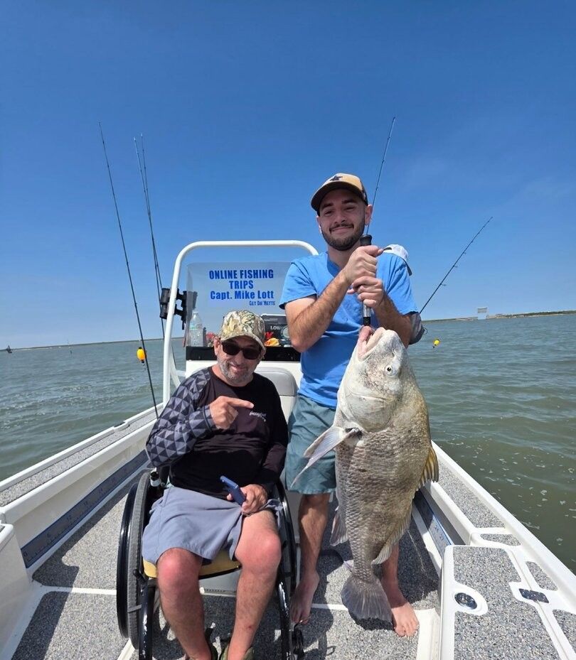 Fishing charter boat with large black drum fish catch displayed on deck