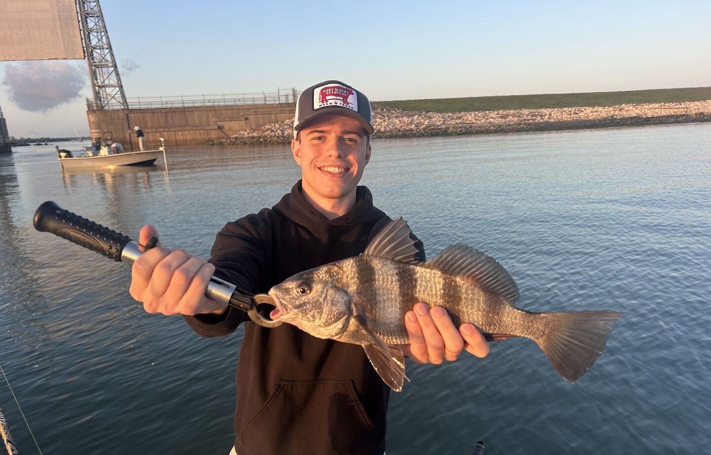 Black drum fish being held after successful catch during fishing trip