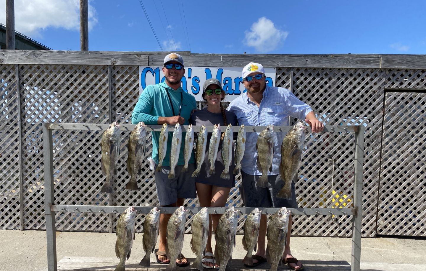 Successful fishing trip showing multiple Black Drum and Speckled Trout displayed on cleaning station