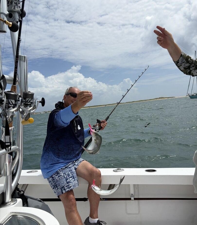 Bluefish caught during offshore fishing trip with fishing rod and boat equipment visible