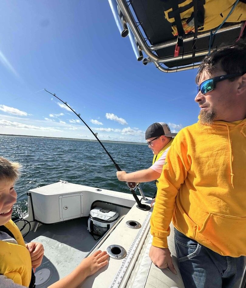 Fishing rod bent with fish on the line during deep sea fishing trip on boat