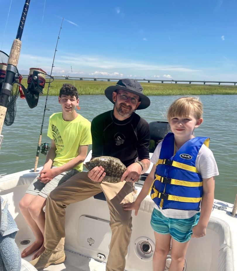 A group of 3 people fishing in an unknown location