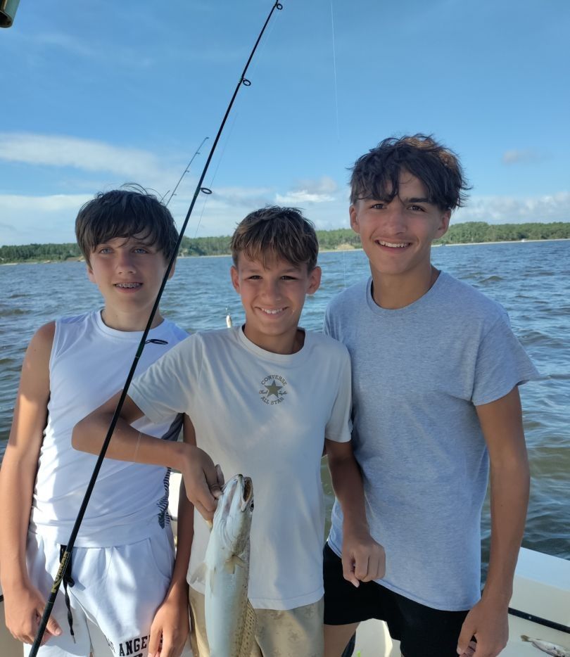 3 people fishing in an unknown location