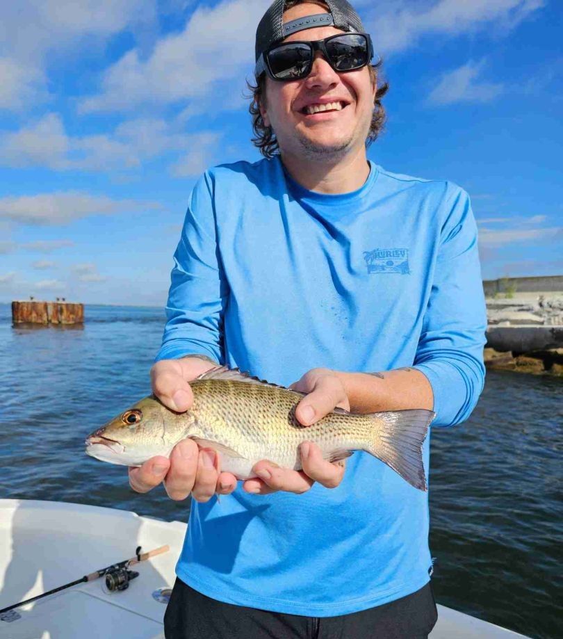 Fisherman enjoying a day of fishing at an unknown location.