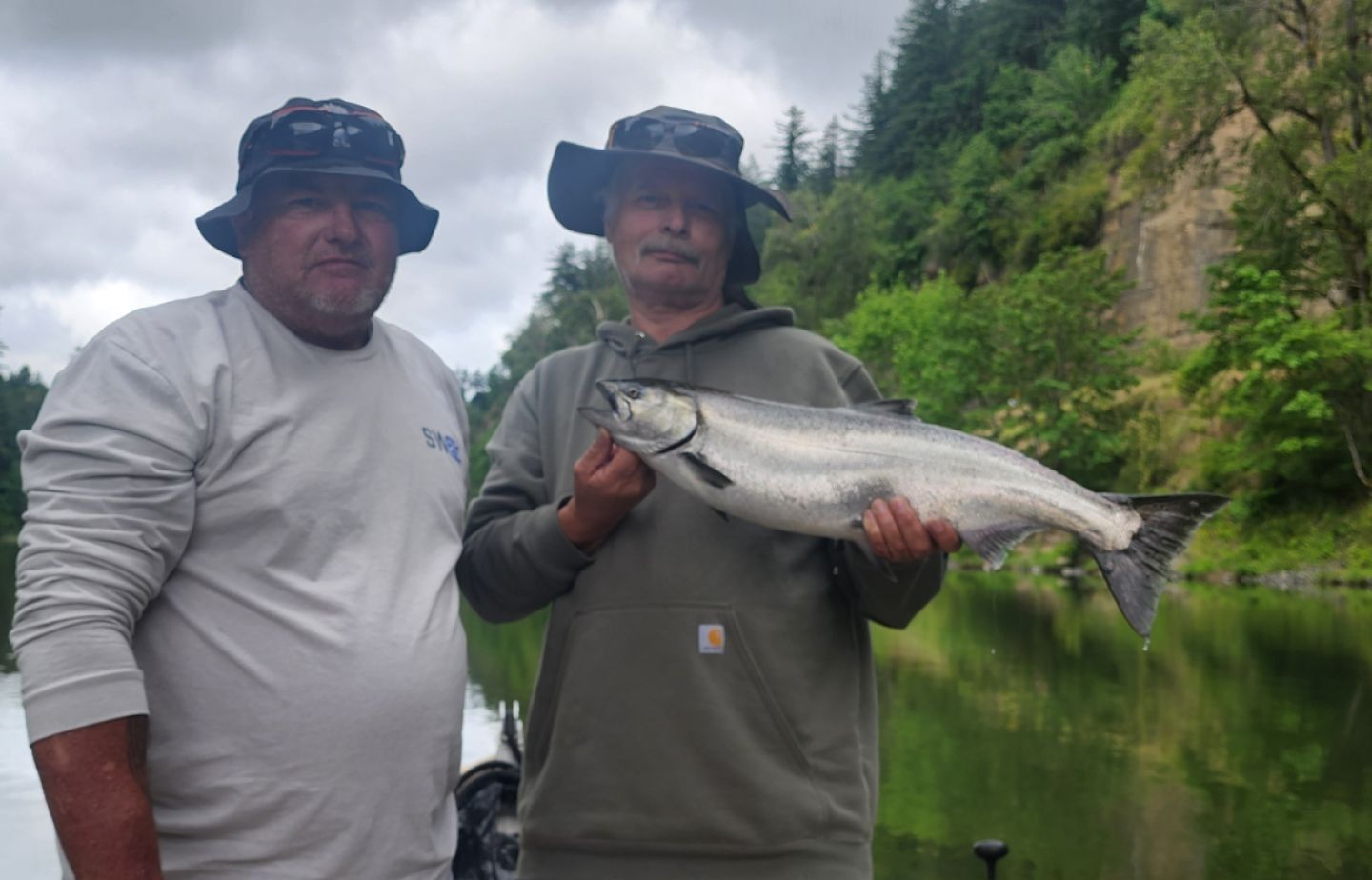 Two people fishing on an unknown body of water