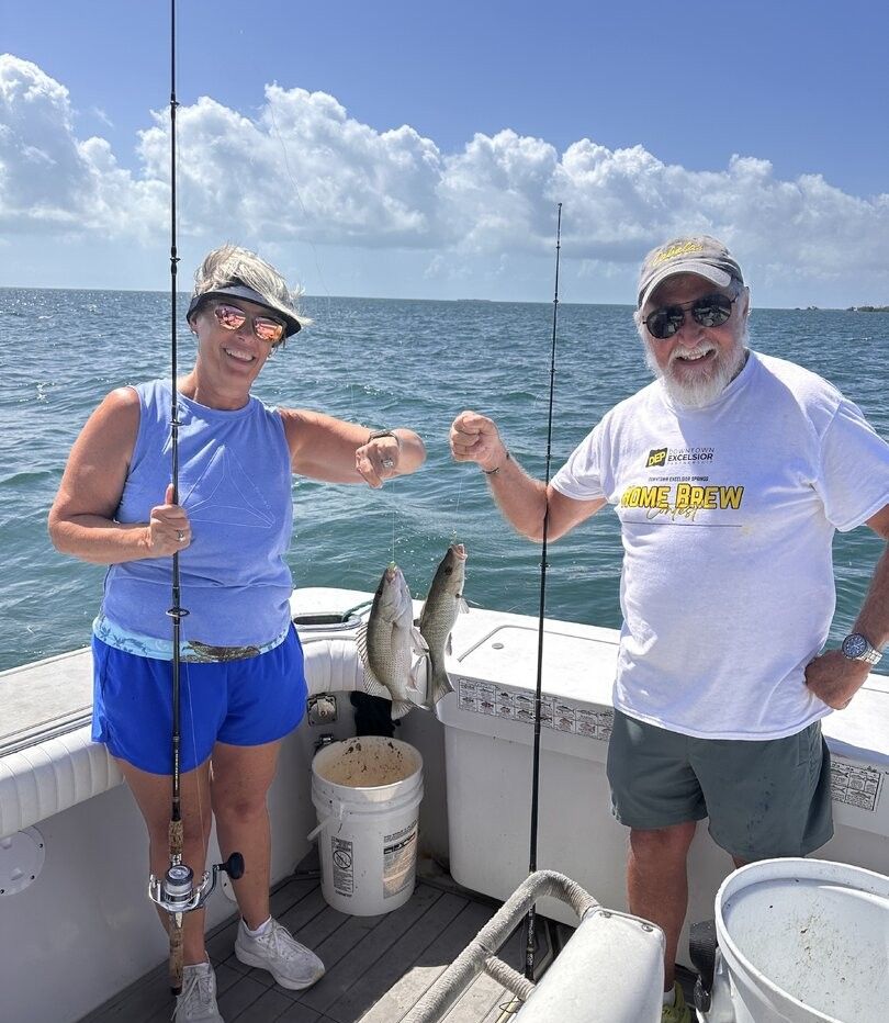 Two freshly caught fish displayed on fishing boat deck with ocean waters in background