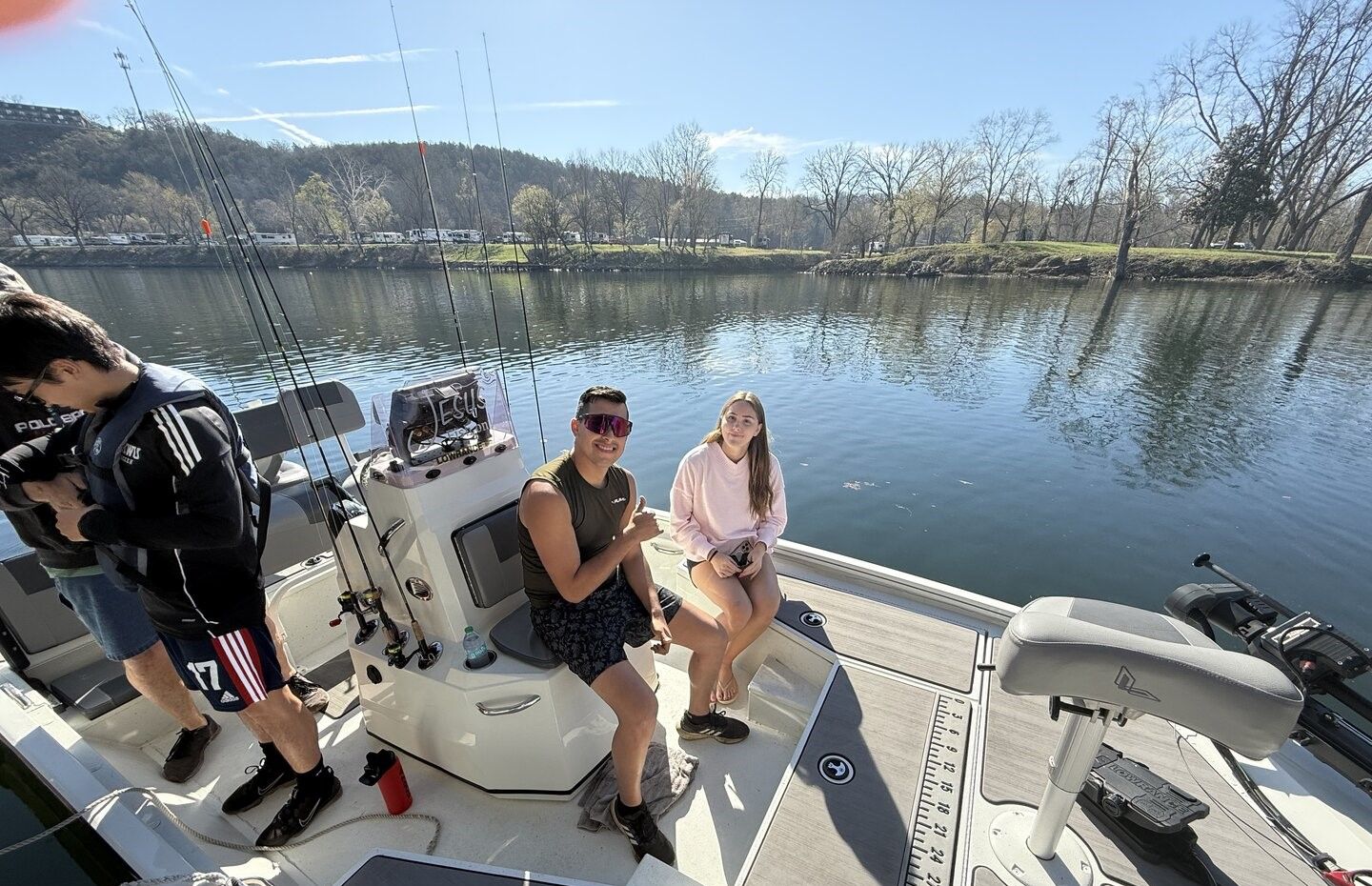 Fishing boat on calm lake with multiple fishing rods and equipment ready for angling