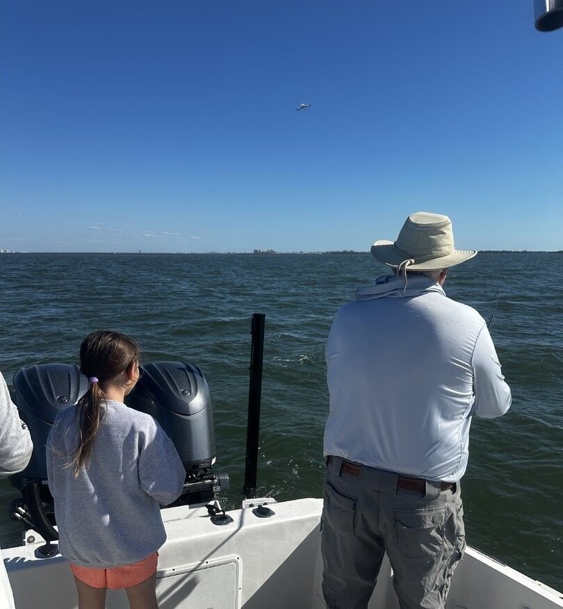 Fishing boat on open water with outboard motors under clear blue sky