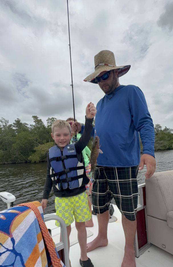 Two people fishing on an unknown body of water