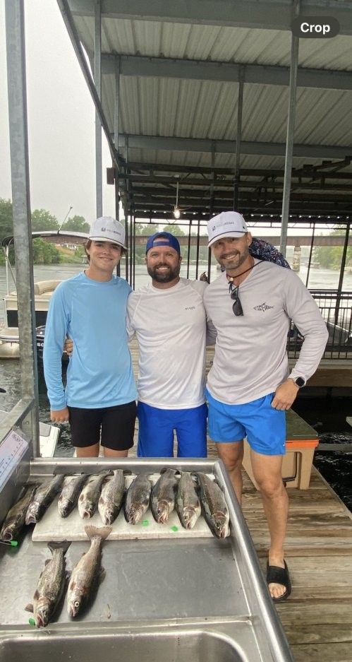 Three people fishing at a scenic location