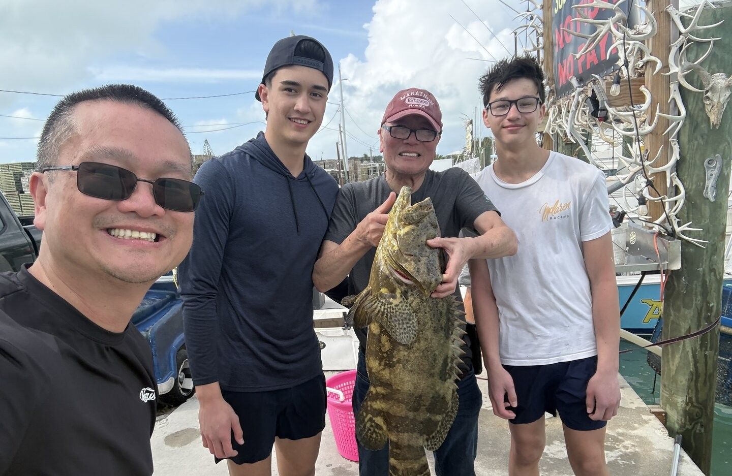 Successful fishing trip with large Goliath Grouper catch displayed at marina dock