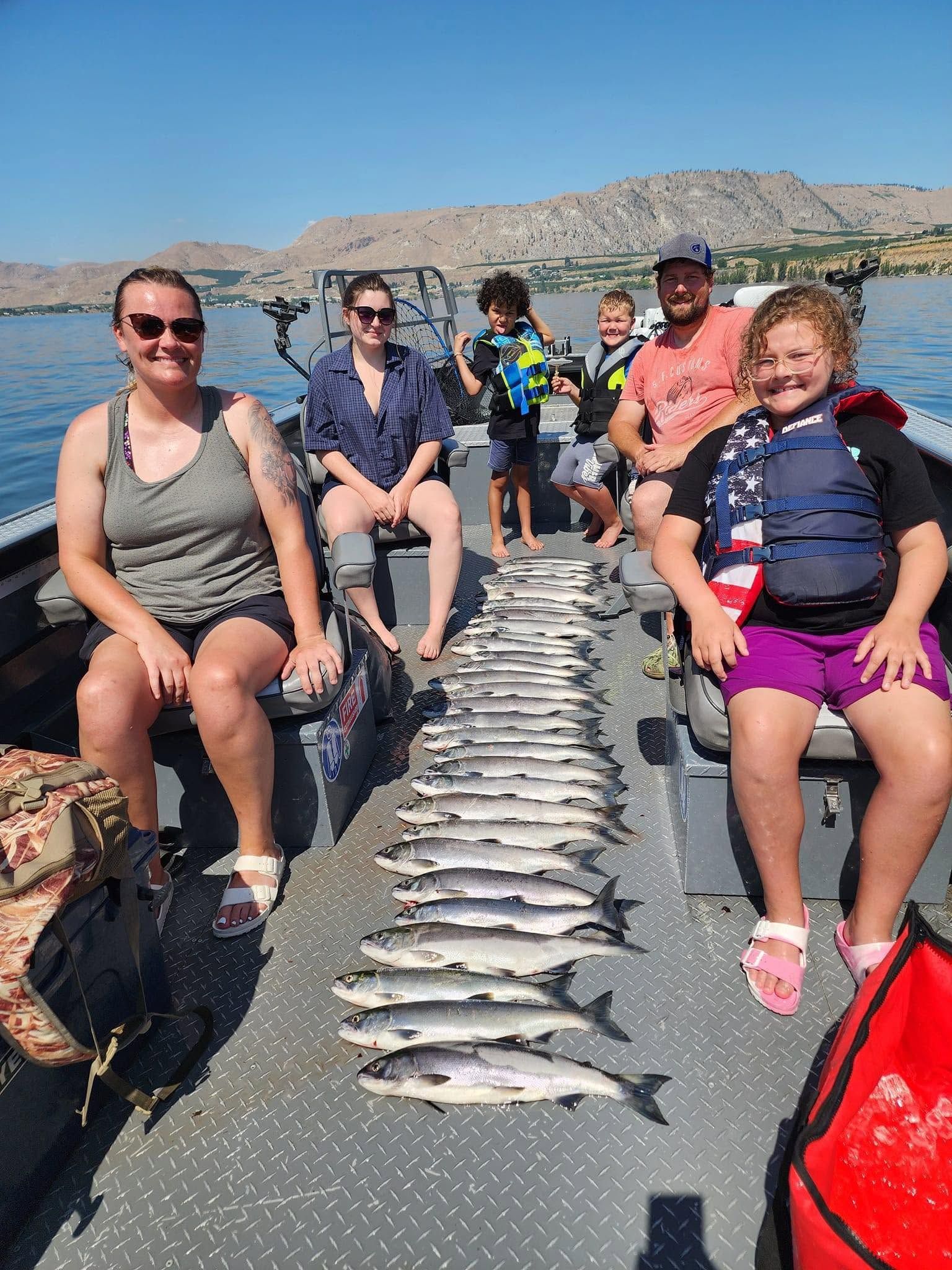 Successful fishing trip with abundant pink salmon catch displayed on boat deck