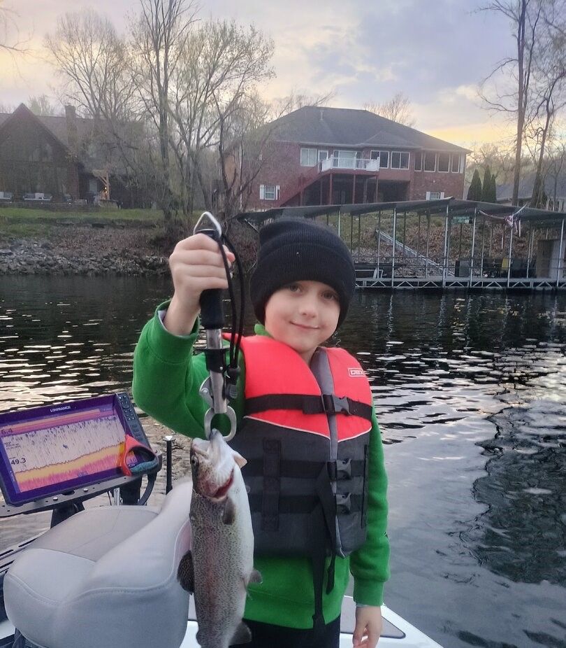 Rainbow trout caught while fishing on lake with residential homes and dock in background
