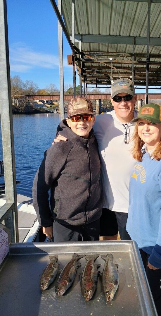 Four rainbow trout displayed on boat deck after successful fishing trip