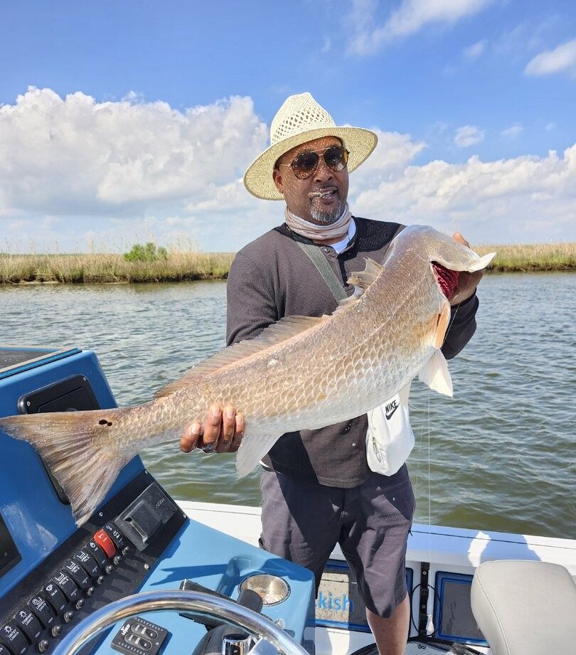 Angler holding large redfish on fishing boat