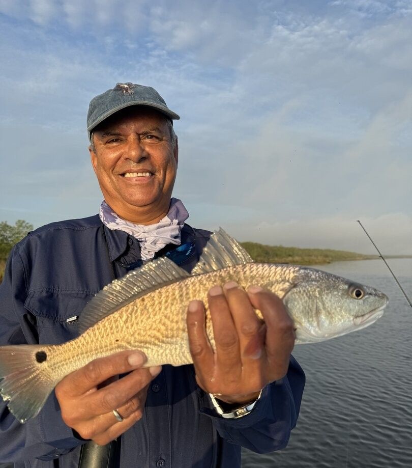 Angler holding freshly caught redfish on fishing boat