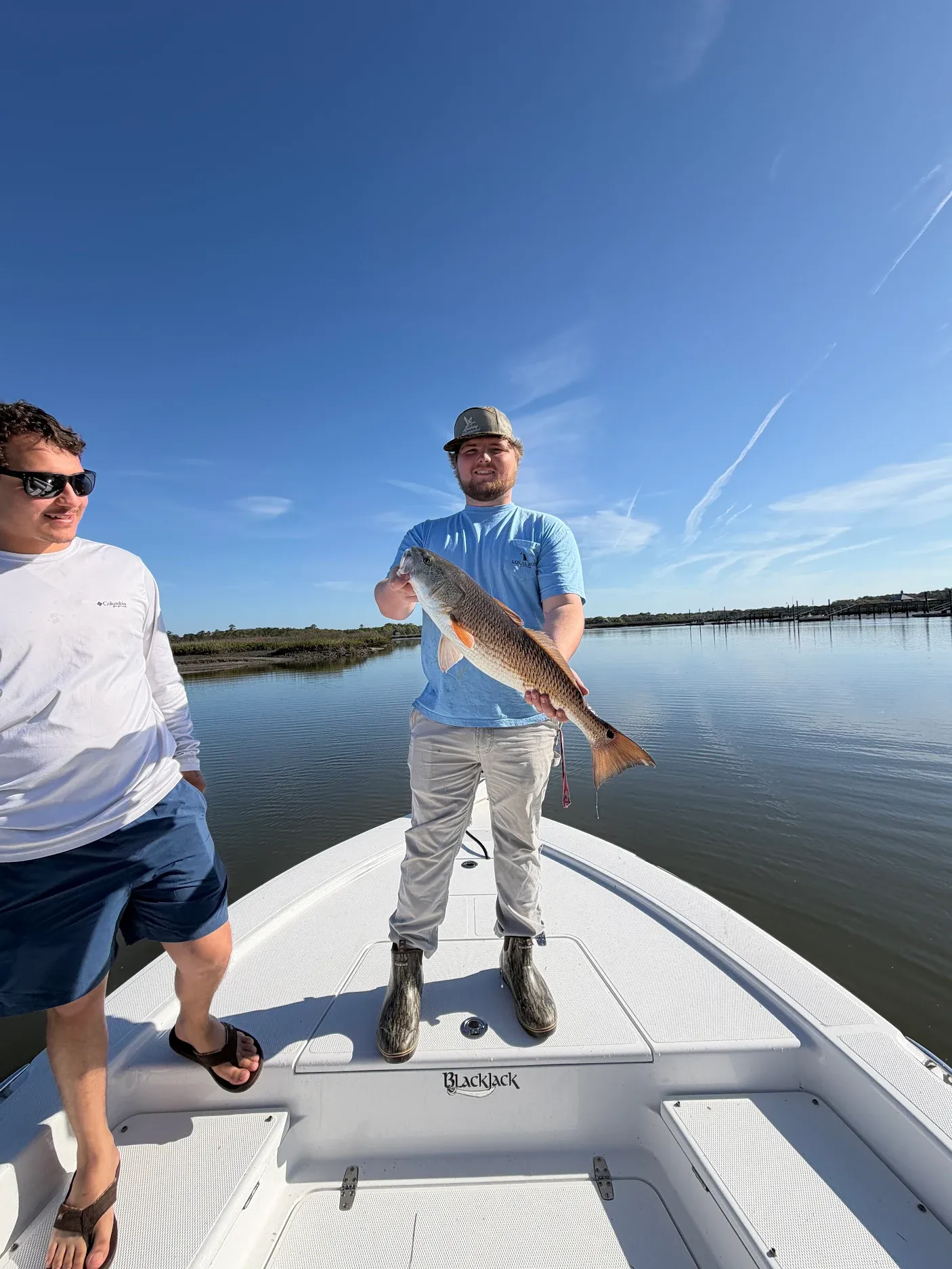 Angler holding freshly caught redfish on fishing boat