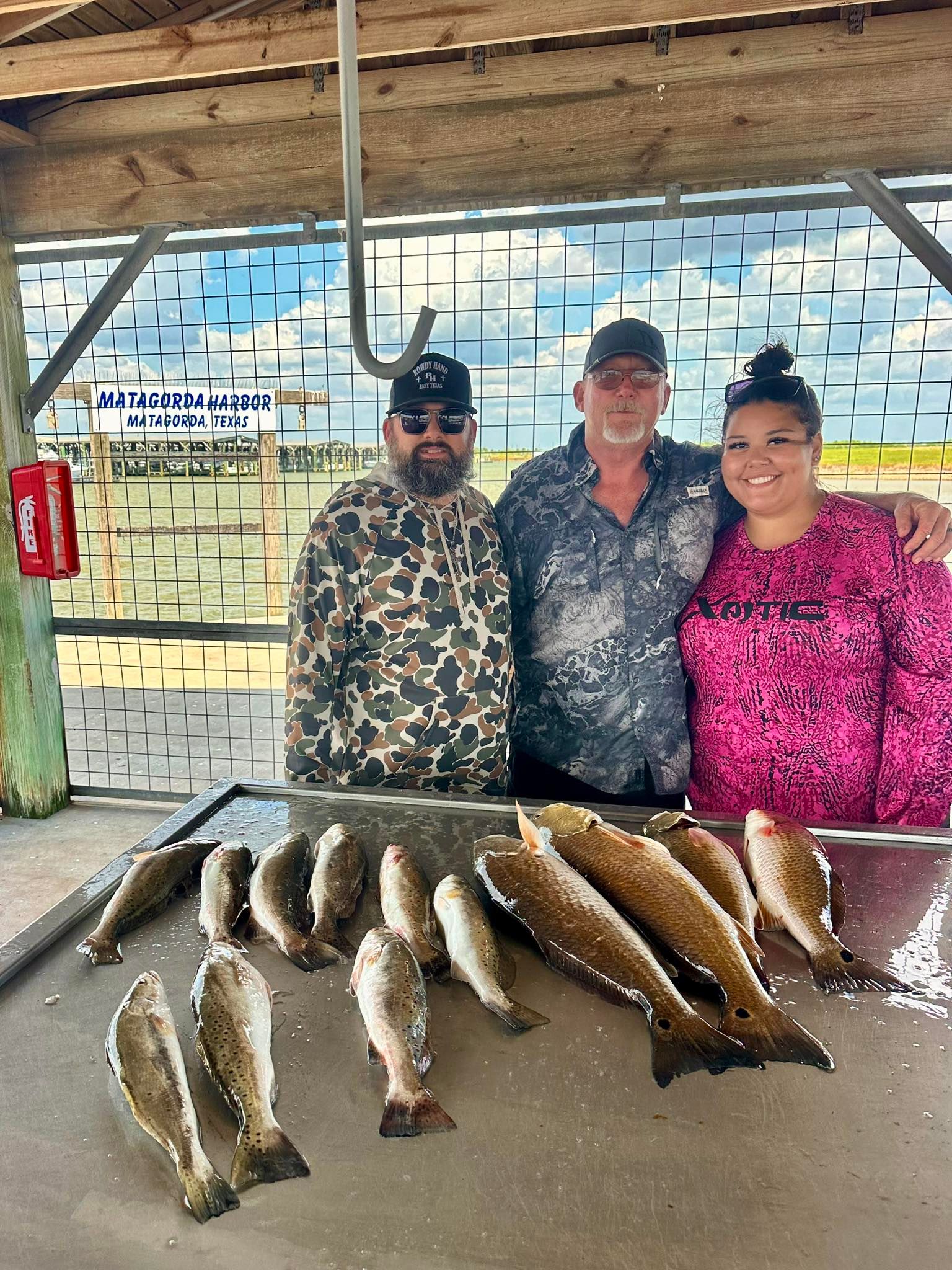 Fresh caught redfish and speckled trout displayed on cleaning table at fishing dock