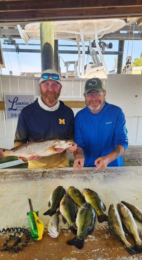 Fishing charter displaying fresh catch of redfish and speckled trout at cleaning station