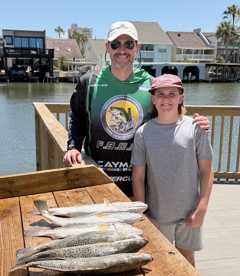 Fresh caught speckled trout displayed on wooden cleaning table at waterfront dock